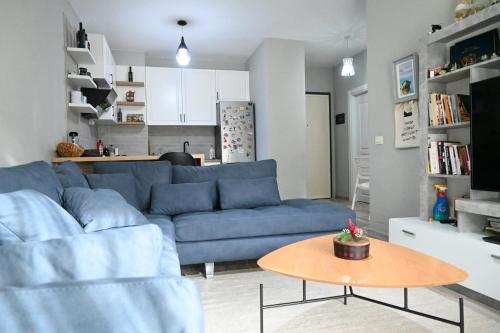 uma sala de estar com um sofá azul e uma mesa em Cozy apartament in Tirana em Tirana