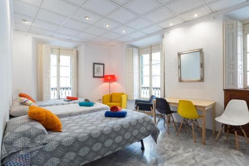 1 dormitorio con 2 camas, mesa y sillas en CALLE LARIOS CENTRO HISTORICO PARKING GRATIS ESPECIAL GRUPOS s1, en Málaga
