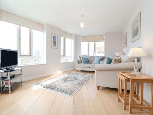 ein Wohnzimmer mit Couch und Fernseher in der Unterkunft 23 Tibby's Way in Southwold