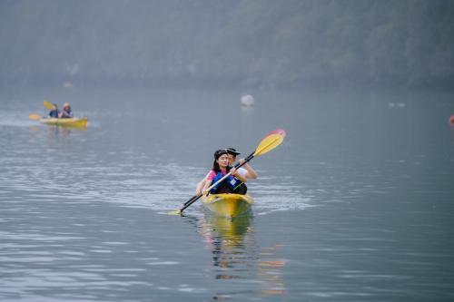 a woman in a kayak in the water at Aqua Of The Seas Cruise Halong in Ha Long