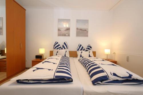 a bedroom with two beds with blue and white pillows at Fischer in Westerland