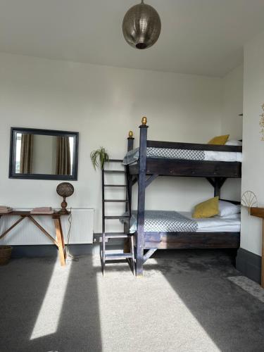 a bedroom with two bunk beds and a mirror at CloudZen in Kent