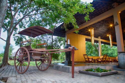 a horse drawn carriage sitting outside of a house at Kassapa Lions Rock in Sigiriya