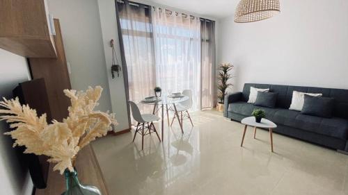 a living room with a couch and tables and chairs at Alojamiento Fragata Lealtad in Moaña