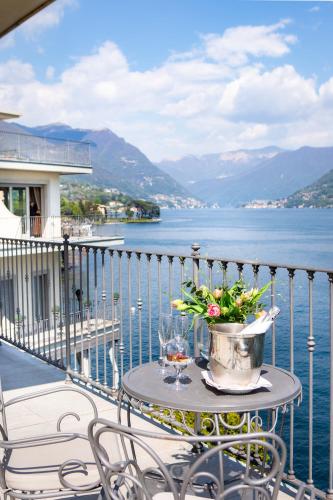 a table on a balcony with a view of the water at Hotel Villa Flori in Como