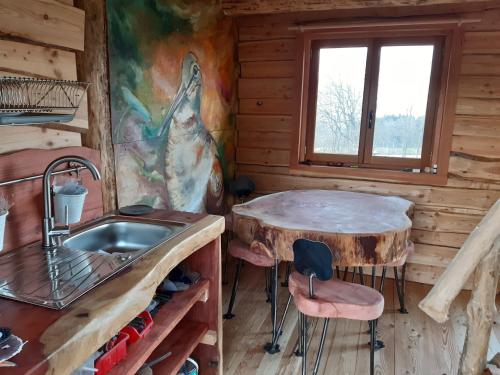 - une cuisine avec un évier et une table dans une cabane en rondins dans l'établissement Les Insolites du Vercors, à Saint-Paul-lès-Monestier