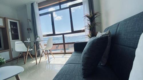 a living room with a couch and a large window at Alojamiento Fragata Lealtad in Moaña