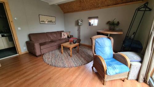 sala de estar con sofá, sillas y mesa en Rust en Stilte in de Natuur, en Onstwedde