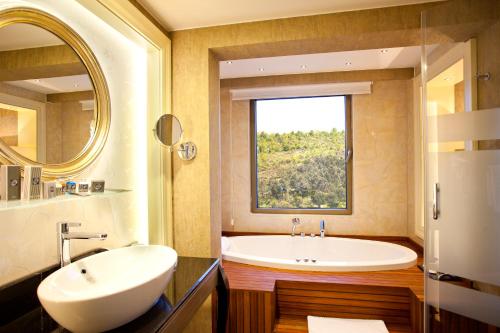 伊斯坦堡的住宿－利馬克歐亞豪華酒店，带浴缸、水槽和窗户的浴室