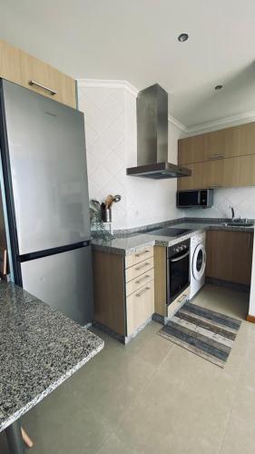 a kitchen with a refrigerator and a stove top oven at Alojamiento Fragata Lealtad in Moaña
