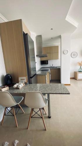 a kitchen with a table and two chairs in a room at Alojamiento Fragata Lealtad in Moaña