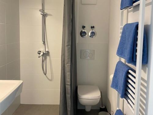 a bathroom with a toilet and a shower with blue towels at Hafenstraße Kassel in Kassel