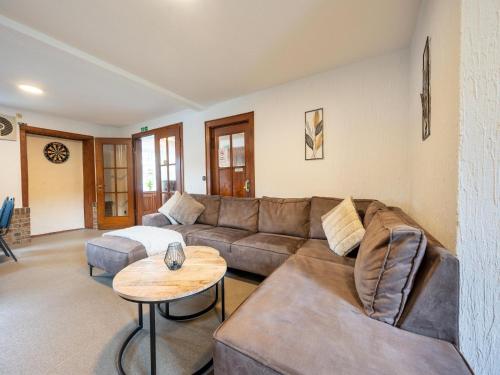 a living room with a couch and a table at Holiday home with sauna in the Eifel National Park in Schleiden