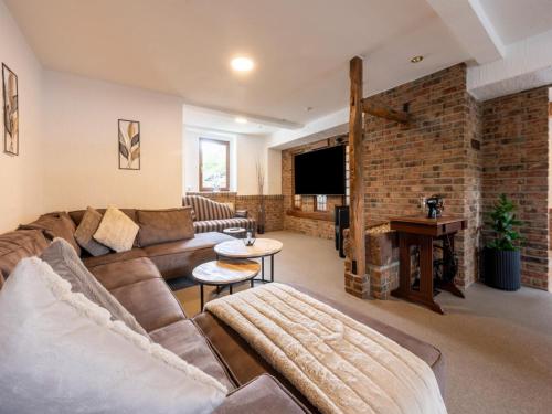 a living room with a couch and a brick wall at Holiday home with sauna in the Eifel National Park in Schleiden