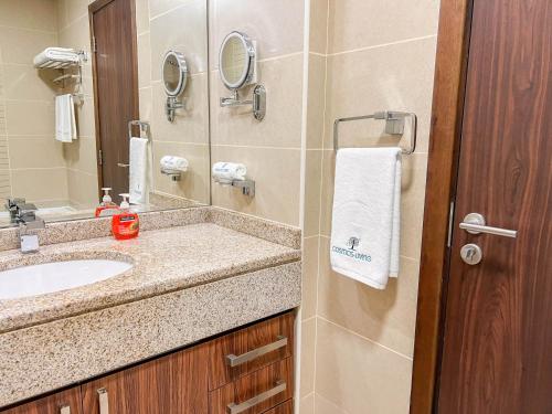 a bathroom with a sink and a mirror at Cosmos Living Luxurious Studio Near Metro in Dubai