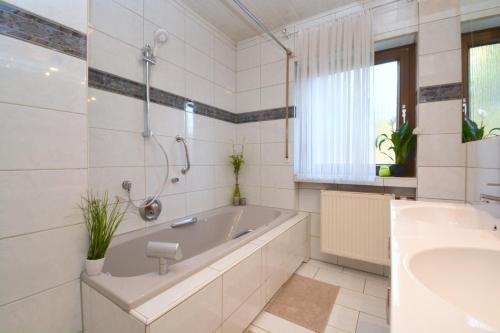 Baño blanco con bañera y lavamanos en NUE10-FW Apartment in Lauf a.d. Pegnitz en Lauf an der Pegnitz