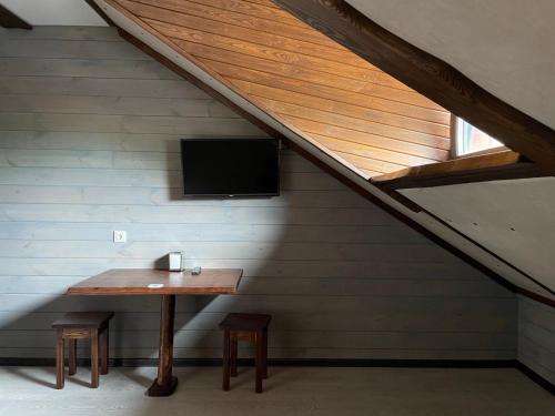 a room with a table and a tv in a attic at Kolyba Club in Stanishovka