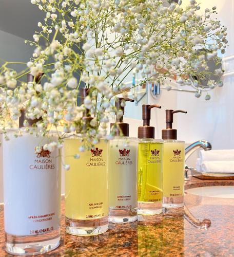 a group of four bottles of soap on a counter at Chambres d'hôtes Relais Mira Peis in Mirepoix