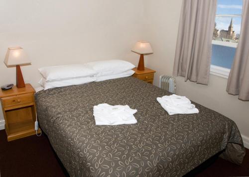 a hotel room with a bed with towels on it at The Alpine Hotel in Cooma