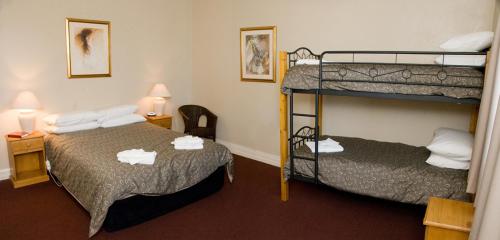 a hotel room with two bunk beds in it at The Alpine Hotel in Cooma