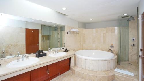 a large bathroom with two sinks and a shower at Hotel Savoy Homann in Bandung