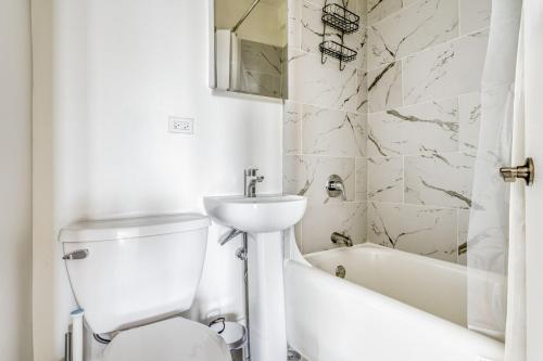 een witte badkamer met een wastafel, een toilet en een bad bij Gold Coast 1br w doorman gym nr Mariano Park CHI-946 in Chicago