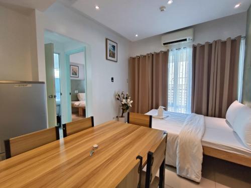 a bedroom with a large bed and a wooden table at Premiere Haven MOA Staycation in Manila