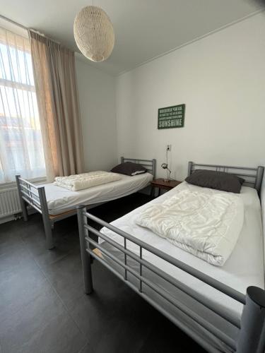Residence het Centrum في أوستكابيلي: غرفة بها سريران ولافتة على الحائط