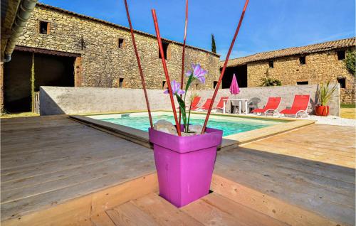un vase violet avec des fleurs assis sur une terrasse dans l'établissement Cozy Home In Saint-Gervais, à Saint-Gervais