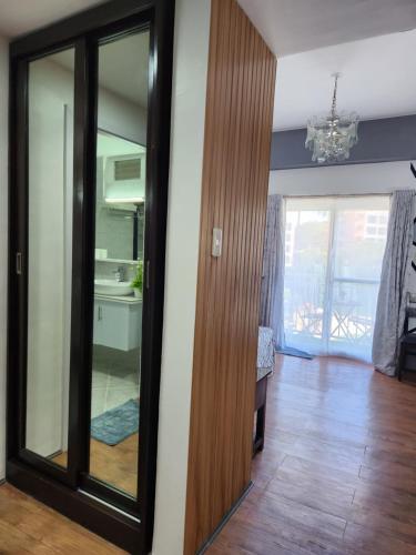 a living room with a mirror and a room with a table at Condo Azur Suites A125 Amani Resorts Residences , 5 minutes Airport, Netflix, Stylish, Cozy with Luxurious Swimming Pool in Pusok