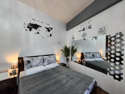1 dormitorio con 2 camas y un mapa mundial en la pared en Condo Azur Suites A125 Amani Resorts Residences , 5 minutes Airport, Netflix, Stylish, Cozy with Luxurious Swimming Pool en Pusok