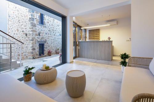 an open living room with a stone wall and glass doors at Molos Apartments in Loutro
