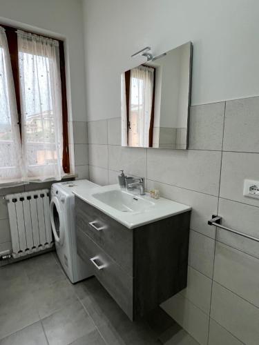 a bathroom with a sink and a washing machine at Casa Girasole in Bardolino