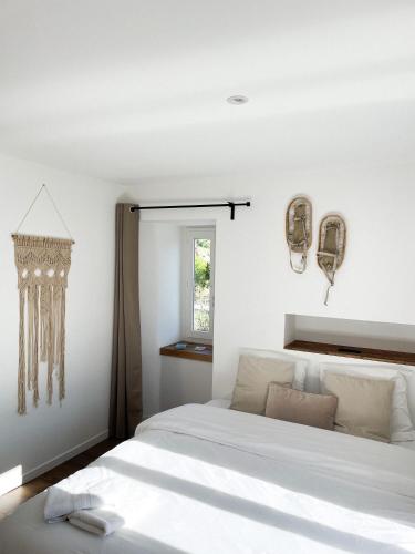 a bedroom with a white bed and a window at STUDIOS Neufs - COEUR de Barcelonnette - Parking privé in Barcelonnette