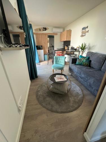 un salon avec un canapé et une table dans l'établissement Charmante maison à 2 pas de la mer avec son jardin pour 2 adultes et 2 enfants, à Merville-Franceville-Plage