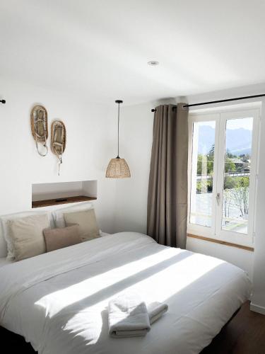 Schlafzimmer mit einem großen weißen Bett und einem Fenster in der Unterkunft STUDIOS Neufs - COEUR de Barcelonnette - Parking privé in Barcelonnette