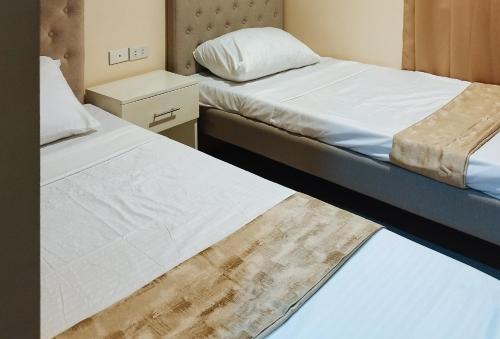 PaviaにあるRedDoorz @ Benelio Suites Pavia Iloiloのベッド2台が隣同士に設置された部屋です。
