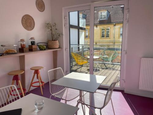 um quarto com uma mesa e cadeiras e uma varanda em Odalys City Metz Manufacture em Metz