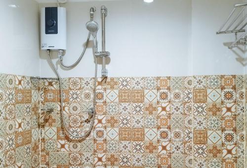 PaviaにあるRedDoorz @ Benelio Suites Pavia Iloiloのタイル張りの壁のバスルーム(シャワー付)