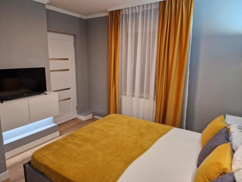 a bedroom with a bed and a flat screen tv at Peaceful&Central apartment with garden in Târgu-Mureş
