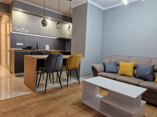a living room with a couch and a table at Peaceful&Central apartment with garden in Târgu-Mureş