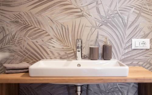 un lavandino bianco in un bagno con parete di Residence Hofgarten a Caldaro