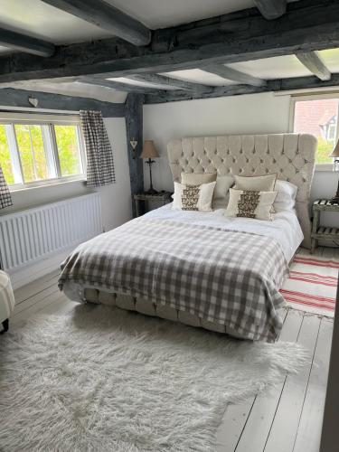 um quarto com uma cama grande e um cobertor xadrez em Spenford House 1640 listed house Idilic Location pub walking distance em Shrewsbury