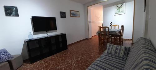 een woonkamer met een bank, een tv en een tafel bij Greta in Torrenueva