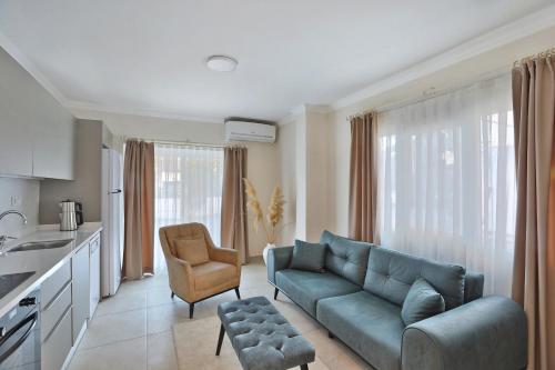a living room with a blue couch and a kitchen at Lavinya Otel in Golturkbuku