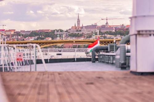 Blick auf eine Brücke über einen Fluss und eine Stadt in der Unterkunft Fortuna Boat Hotel Budapest in Budapest