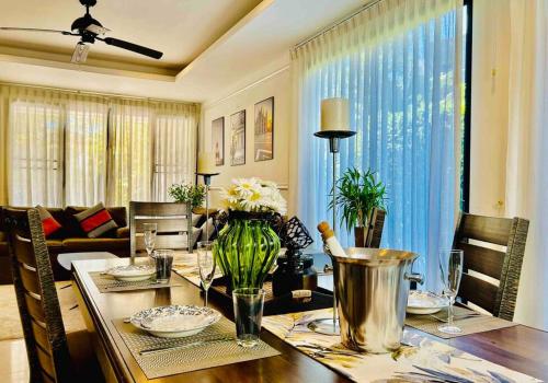 a dining room table with a vase of flowers on it at Country club townhouse in Bang Tao Beach