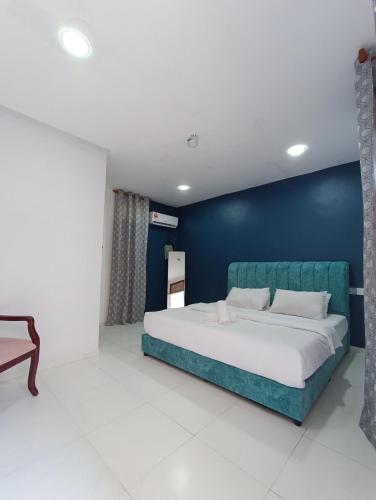 a bedroom with a large bed with a blue wall at RVH Kuala Terengganu in Kuala Terengganu