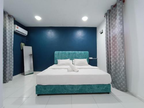 a bedroom with a large bed with a blue wall at RVH Kuala Terengganu in Kuala Terengganu