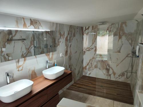 une salle de bain avec deux lavabos et une douche dans l'établissement Villa FG, à Mougins